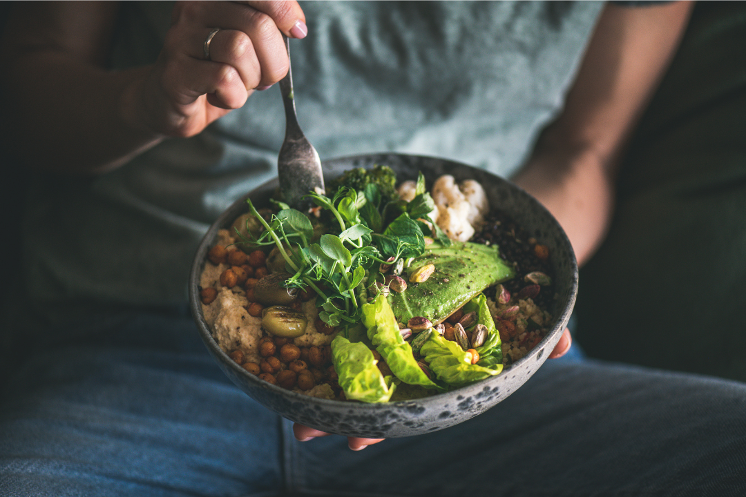 Bowl of protein-rich vegan food with avocado, chickpeas, greens, and grains, ideal for macro-balanced meal plans using Unchecked Fitness AI nutrition tracker.
