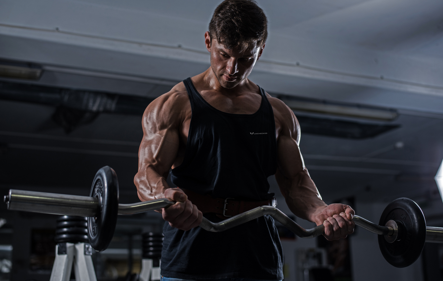 Man building muscle with personalized workout plan from Unchecked Fitness app focused on protein tracking and strength training.